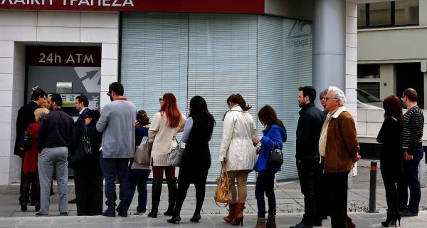People queue to make transactions at an ATM outside a branch of Laiki Bank in Nicosia.  Photograph: Yannis Behrakis/Reuters  