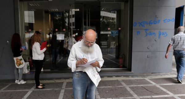 A man checks a document as he leaves a Greek Manpower Employment Organisation  office in central Athens May 9, 2013. Greece’s jobless rate rose to 27 per cent in February. Photograph: John Kolesidis/Reuters. 