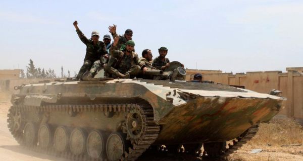 Soldiers loyal to the Syrian regime gesture while on their military vehicle in the village of Debaa near Qusayr. Photograph: Rami Bleible/Reuters 