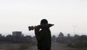An Israeli soldier carries a mortar shell outside the central Gaza Strip on Thursday. A three-day ceasefire is to begin at 8am. Photograph: Reuters/Baz Ratner 