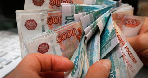 An employee counts Russian rouble banknotes at a small private shop selling home appliances in Krasnoyarsk. Photograph: Ilya Naymushin/Reuters