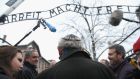  Journalists speak to an Auschwitz survivor at the notorious “Arbeit Macht Frei” entrance gate at the former concentration camp, which is now a museum in Oswiecim, Poland. Photograph:  Sean Gallup/Getty Images.