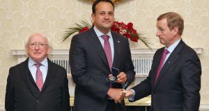 Minister for Social Protection Leo Varadkar with President Michael D Higgins and Taoiseach Enda Kenny after receiving his seal of office at Áras an Uachtarain on Friday night. 