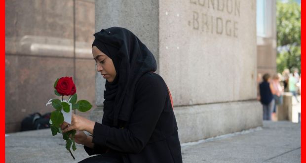A woman prepares to give out roses on London Bridge with messages of “love and solidarity”. Photograph: David Mirzoeff/PA