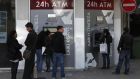 People wait to use the ATM machines outside a Laiki Bank branch in the Cypriot capital  Nicosia yesterday. Photograph: Petros Karadjias