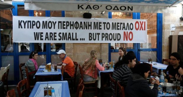 People eat at a restaurant under a banner placed by the owner in central Nicosia. The banner reads: “My proud Cyprus with the big No.” 