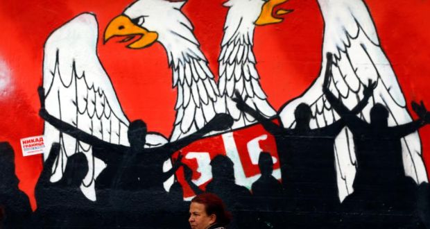 A woman walks past a mural  last week  depicting part of the Serbian coat of arms in the northern, Serb-dominated part of the ethnically divided town of Mitrovica in Kosovo.  Photograph: Marko Djurica/Reuters 