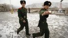 A Chinese border guard tries to stop his picture from being taken as he and his compatriot patrol the Tumen river in China’s Jilin province, across from North Korea. Photograph: Peter Parks/AFP/ getty images