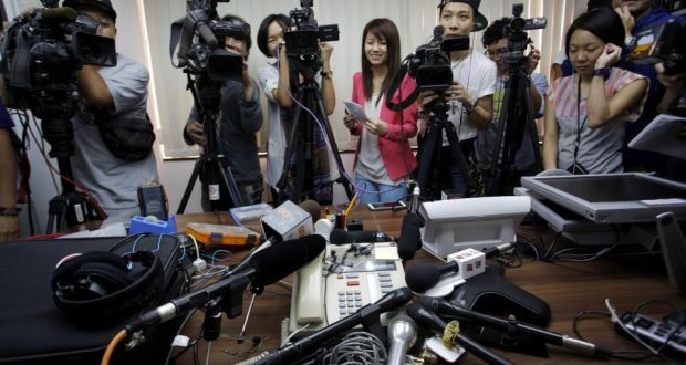 Reporters crowd around a speakerphone as they listen to a transgender woman it after she won a legal ruling at Hong Kong’s top court allowing her to marry her boyfriend.