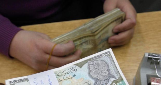 An employee counts Syrian pound notes at the Syrian central bank in Damascus. The Syrian pound has lost about 60 per cent of its value against the US dollar in two years. Photograph: Reuters/Khaled al-Hariri