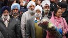 Members of the Sikh community wait to lay flowers yesterday close to the crime scene in Woolwich, London, where 25-year-old soldier Lee Rigby was murdered on Wednesday. Photograph: Dan Kitwood/Getty Images