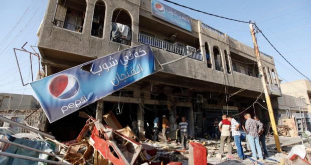 Residents gather yesterday at a coffee shop that was destroyed in a suicide bomb attack in Baghdad. Five people were killed and 20 were wounded in the attack on Sunday night. Photograph: Saad Shalash/Reuters