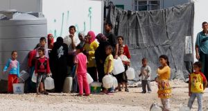 Syrian refugees wait to collect water at the Al Zaatri refugee camp in the Jordanian city of Mafraq, near the border with Syria yesterday. Photograph: Muhammad Hamed/Reuters