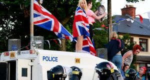 Loyalist protesters climb on an armoured police vehicle in the Woodvale Road area of North Belfast last night. Photograph: Cathal McNaughton/Reuters