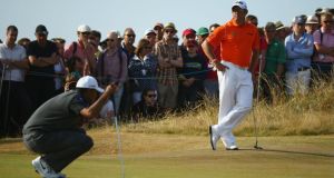Tiger Woods of the United States lines up a putt as Lee Westwood of England watches on the 13th green  at Muirfiel. Photograph: Matthew Lewis/Getty Images