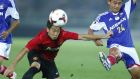 Manchester United’s Shinji Kagawa wins the ball ahead of  Yuta Narawa of F-Marinos earlier today. F-Marinos won 3-2. 
