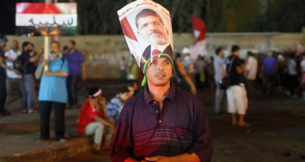 A supporter of deposed Egyptian president Mohamed Morsi, wearing a Morsi poster around his head, stands with other protesters during an anti-army rally that started from their sit-in area around Raba’ al-Adawya mosque, in Nasr City area, east of Cairo today. Photograph: Reuters. 