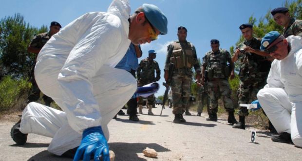 Scientific investigators, part of the UN peacekeeping force in south Lebanon, inspect the site near an explosion as Lebanese army soldiers watch near the Lebanese-Israeli border in the village of Labbouneh, southern Lebanon, yesterday. Photograph: Reuters 