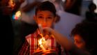 A Palestinian boy holds a candle during a vigil to show solidarity with Syrian civilians in the West Bank city of Ramallahafter hundreds were killed yesterday in rebel-held Damascus suburbs. The United Nations has demanded that Syria gives its chemical weapons experts immediate access to the suburbs where poison gas appears to have killed hundreds just a few miles from the UN team’s hotel. Photograph: Mohamad Torokman/Reuters