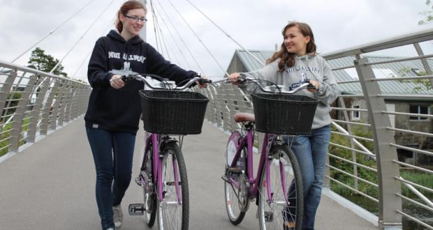 Laura O’Connor and Eleonora Fetter with two of the purple bikes that are part of the new cycle-sharing scheme in Galway.