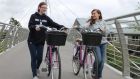 Laura O’Connor and Eleonora Fetter with two of the purple bikes that are part of the new cycle-sharing scheme in Galway.