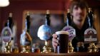 A Wetherspoon employee serves a pint of beer at one of the company’s pubs in London. The chain is planning to move into the Irish market next year, according to chairman Tim Martin.  Photographer: Matthew Lloyd/Bloomberg