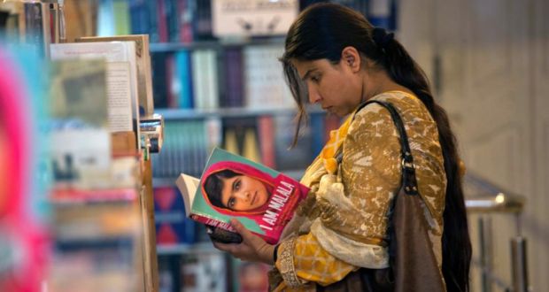 A woman browses a copy of Malala Yousufzai’s book “I am Malala” at a book store in Islamabad. Photograph: Reuters