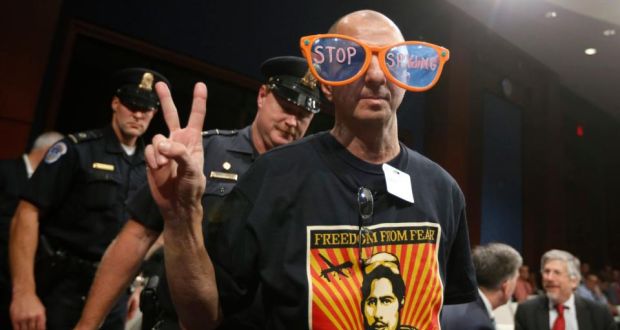 A protester against US spying is escorted by Capitol Police from a hearing yesterday in which US director of national intelligence James Clapper testified on potential changes to the Foreign Intelligence Surveillance Act. Photograph: Jason Reed/Reuters