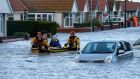 Emergency rescue service workers evacuate residents from flood waters in an inflatable boat in flood in Rhyl, north Wales. Photograph: Phil Noble/Reuters.