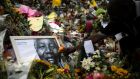 A man places flowers in tribute to former South African president Nelson Mandela outside his house in Johannesburg  today. Photograph: Reuters