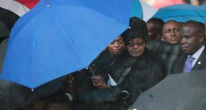 Winnie Madikizela-Mandela sits under an umbrella during the official memorial service for her ex husband and former South African President Nelson Mandela. Photograph: Christopher Furlong/Getty Images