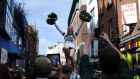 A member of the Notre Dame cheerleading squad is held aloft in Dublin’s Temple Bar ahead of their American footbal match against Navy in September. Photograph: Aidan Crawley/The Irish Times