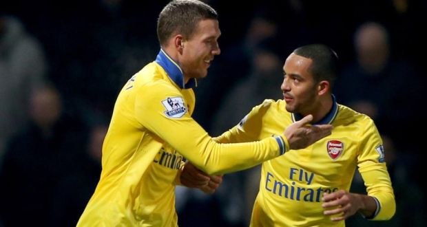 Lukas Podolski (left) celebrates with Theo Walcott after scoring Arsenal’s third goal during the Premier League match against West Ham United at Upton Park. Photograph: Ian Walton/Getty Images.