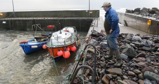  Fisherman Tom Dineen works   to save a boat from the weather at Ballyheigue beach in Co Kerry, where  waves  pushed rocks hundreds of feet over a pier. Photograph: Domnick Walsh/Eye Focus 