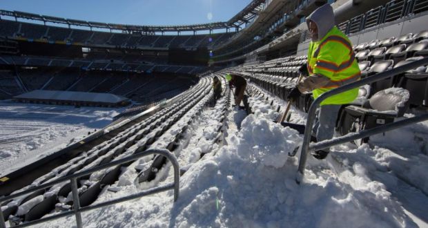 Workers attempt to clear a snow-covered MetLife Stadium in New Jersey last week. Photograph: New York Times