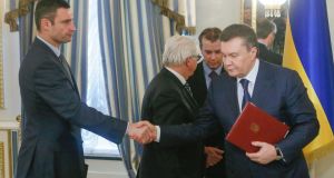 Ukrainian President Viktor Yanukovych (right) and opposition leader Vitali Klitschko (left) shake hands after signing the agreement in the Presidential Palace in Kiev, today. Photograph: Sergey Dolzhenko/EPA