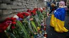 A young girl lays flowers left for anti-government demonstrators killed in clashes with police  in Kiev. Photograph:  Jeff J Mitchell/Getty Images