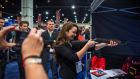 Jenica Krall  tries her hand at a virtual shooting booth at the 41st annual Conservative Political Action Conference  in National Harbor, Maryland. Photograph: Jim Lo Scalzo/EPA