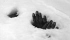 A pair of bound hands and a breathing hole in the snow at Yangji, Korea, on January 27th, 1951 reveal the presence of the body of a Korean civilian shot and left to die by retreating communists during the Korean War. Photograph: AP Photo/Max Desfor