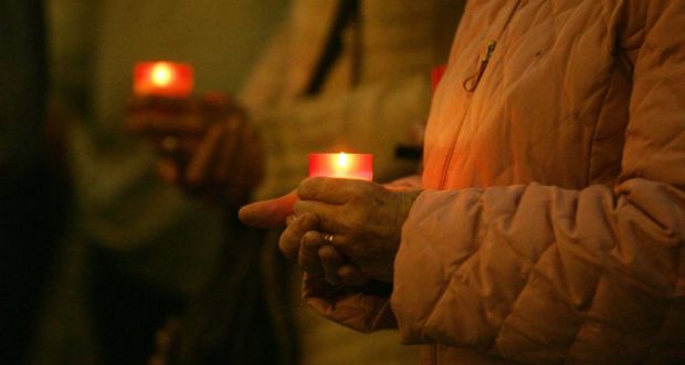 A woman holds a candle during a vigil at College Green, Dublin, remembering those lost to suicide
