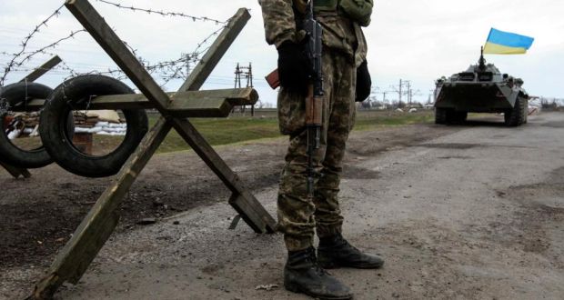 A Ukrainian soldier  guards a checkpoint near the village of Salkovo, in the Kherson region adjacent to Crimea. Photograph: Valentyn Ogirenko/Reuters