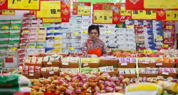 An employee arranges stock under price tags at a supermarket in Huaibei, Anhui province. Photograph: Reuters