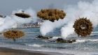 Amphibious assault vehicles of the South Korean Marine Corps launch  smoke bombs as they move to land on shore during a joint US-South Korea military drill in Pohang today. Photograph: Kim Hong-Ji/Reuters
