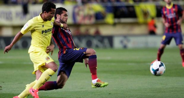 Barcelona’s Dani Alves and Villarreal’s Giovani Dos Santos fight for the ball during the match last Sunday. 