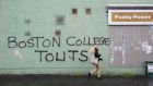 A woman walks past graffiti, a reference to a project by Boston College, on a wall off the Falls Road, Belfast. Photograph: Paul Hackett/Reuters