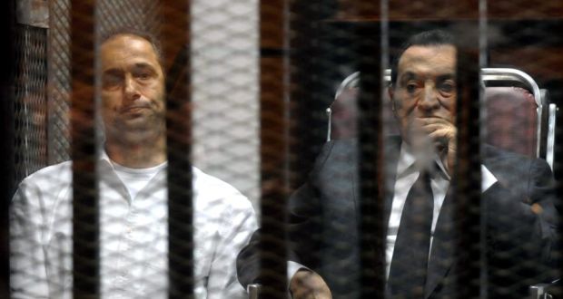  Former Egyptian president Hosni Mubarak (right) and his son Gamal look on from the defendants’ cage inside the courtroom during a sentencing session in Cairo yesterday.  Photograph: Ahmed Almasry/EPA