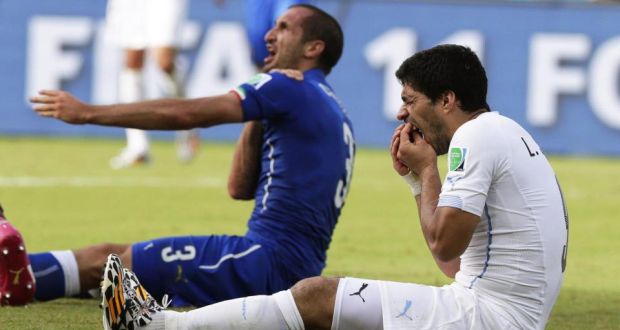 Italy’s Giorgio Chiellini  complains to the referee and claims he was bitten by Uruguay’s Luis Suarez. 
