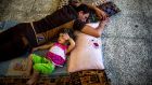 A Sunni man sleeps next to his daughter at a school where they are seeking refuge after fleeing their homes, in Darbandikhan, Iraq. Photograph: Bryan Denton/The New York Times