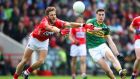 Kerry’s Paul Geaney gets his shot away despite the efforts of Cork’s   Eoin Cadogan during the   Munster SFC Final. Photograph:  Cathal Noonan/Inpho