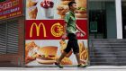 A pedestrian walks past an advertisement for McDonald’s  in the Futian district of Shenzhen, China. Photographer: Brent Lewin/Bloomberg